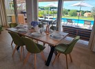Grosser, moderner Esstisch mit Blick auf Pool und Garten